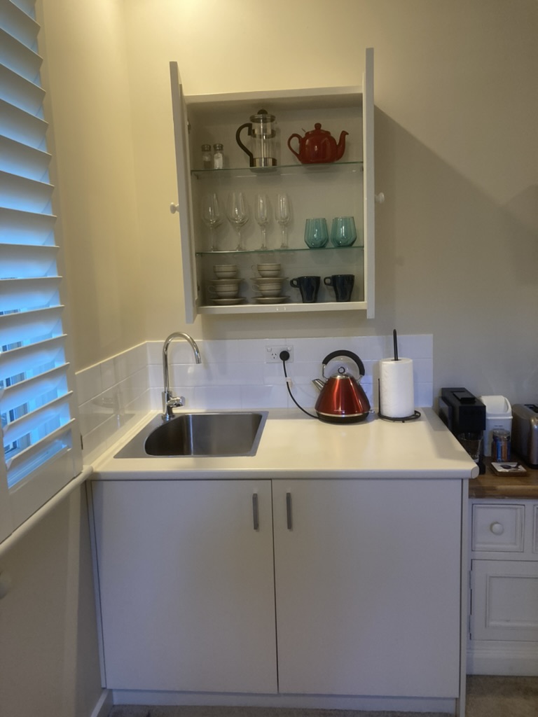 New glassware cabinet installed above the kitchenette sink.