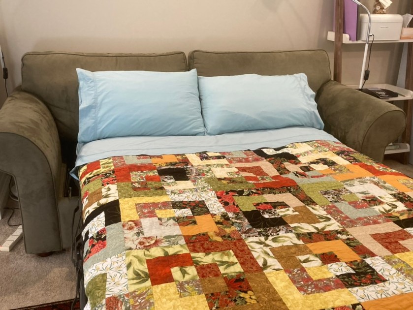 Beautiful handmade quilt on the sofa bed in the lounge
